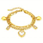 Gold plated bracelet with heart and cubic zirconia charms on a white background
